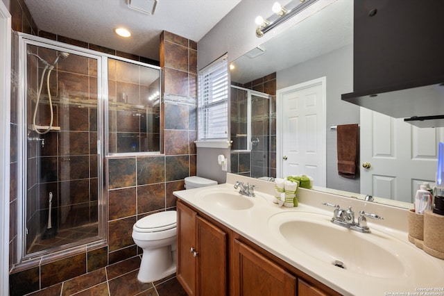 bathroom with tile patterned floors, toilet, a textured ceiling, and walk in shower