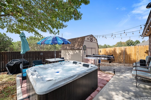 view of patio with area for grilling, a hot tub, and a storage shed