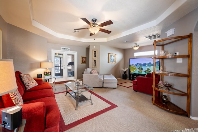 carpeted living room featuring ceiling fan, french doors, and a tray ceiling