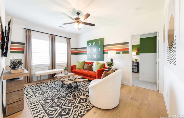 living room featuring ceiling fan and light hardwood / wood-style floors