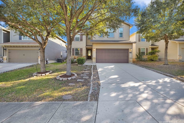 view of front of house featuring central AC unit, a garage, and a front yard