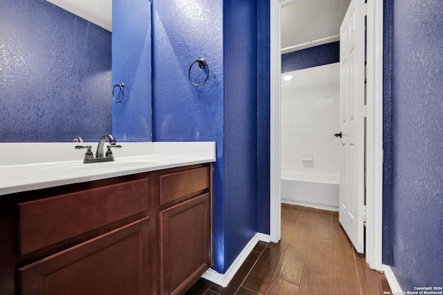 bathroom with vanity, washtub / shower combination, and hardwood / wood-style flooring