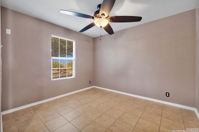 tiled spare room featuring ceiling fan