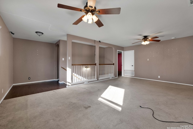 empty room with ceiling fan and dark carpet