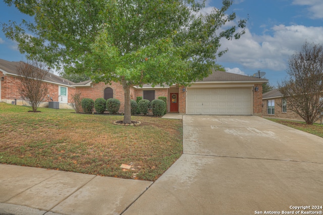 view of front of home featuring a front lawn, central AC unit, and a garage