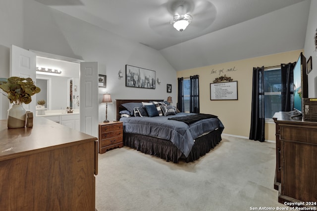 bedroom featuring ensuite bathroom, ceiling fan, light carpet, and vaulted ceiling