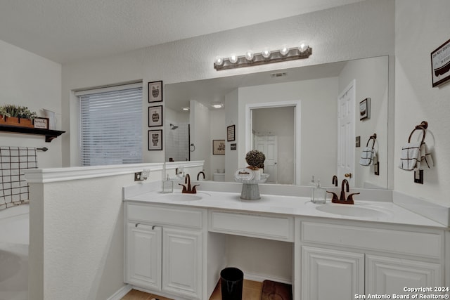 bathroom featuring a textured ceiling, vanity, and shower with separate bathtub