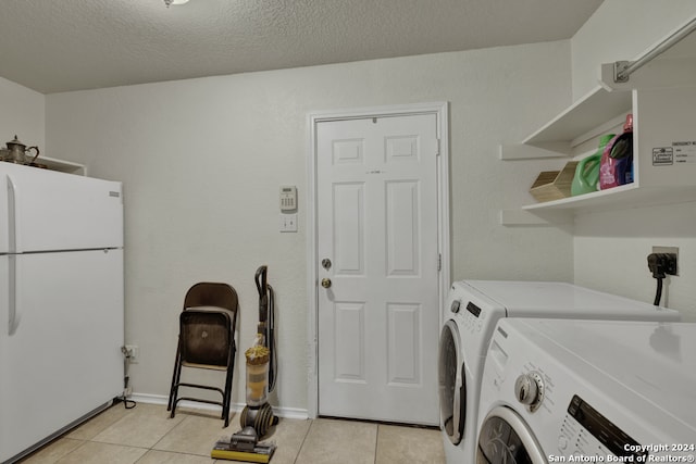 laundry area with independent washer and dryer, a textured ceiling, and light tile patterned floors