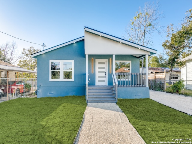 bungalow-style home featuring covered porch and a front lawn