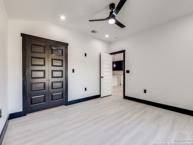 unfurnished bedroom with light wood-type flooring, ceiling fan, and lofted ceiling