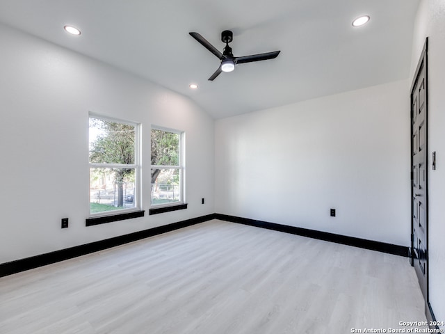 empty room with ceiling fan, light hardwood / wood-style floors, and lofted ceiling