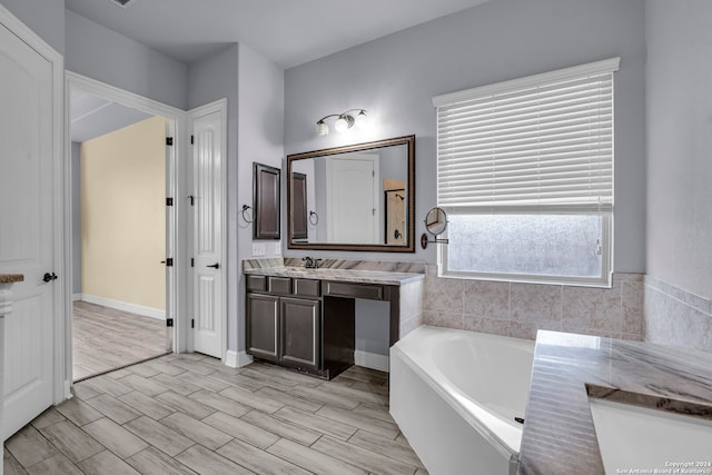 bathroom with hardwood / wood-style floors, vanity, and a bathtub