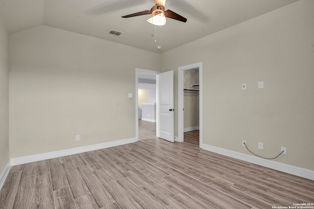 unfurnished bedroom featuring light wood-type flooring, a closet, ceiling fan, and lofted ceiling