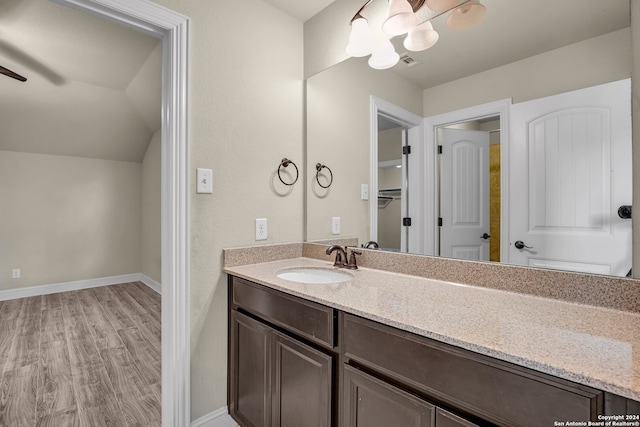 bathroom with wood-type flooring, vanity, ceiling fan, and lofted ceiling