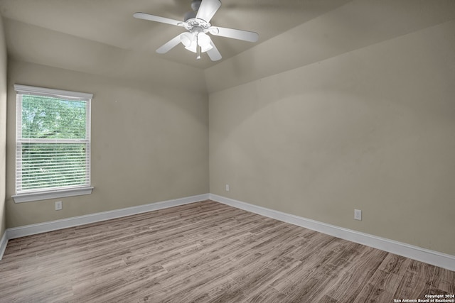 empty room with ceiling fan and light hardwood / wood-style flooring