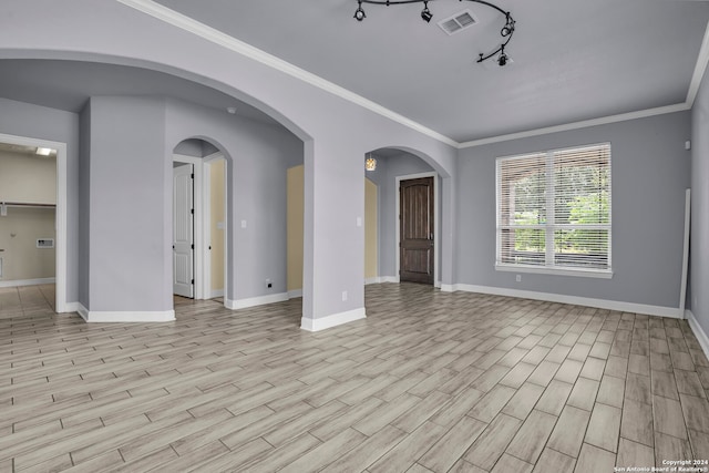 unfurnished room with track lighting, crown molding, and light hardwood / wood-style flooring