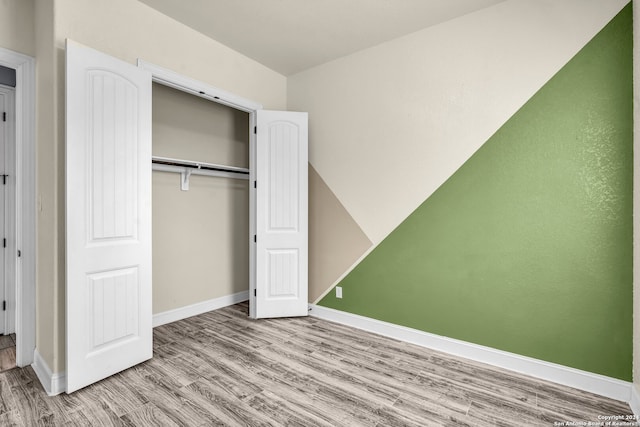 unfurnished bedroom featuring light hardwood / wood-style flooring and a closet