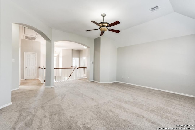 carpeted spare room featuring ceiling fan and vaulted ceiling