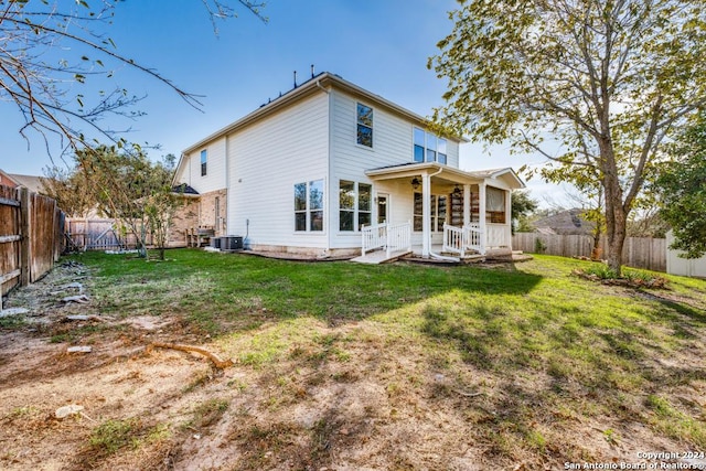 rear view of property with cooling unit and a yard