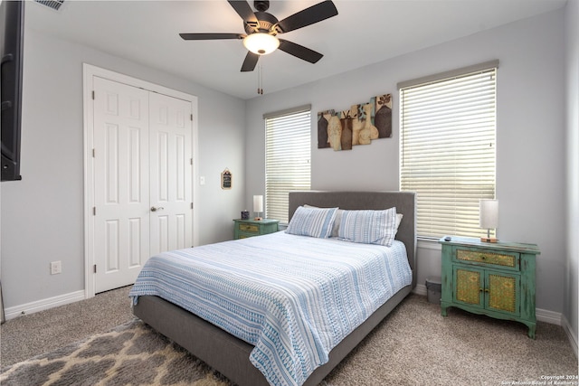 carpeted bedroom with ceiling fan and a closet