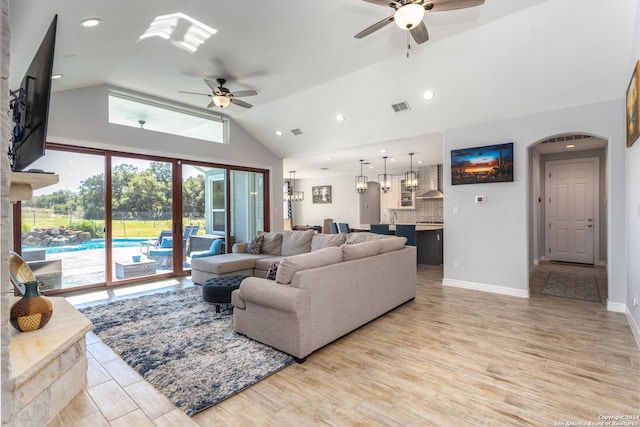 living room featuring light hardwood / wood-style floors, vaulted ceiling, and ceiling fan