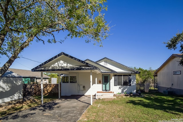 bungalow-style home with a front lawn and a carport