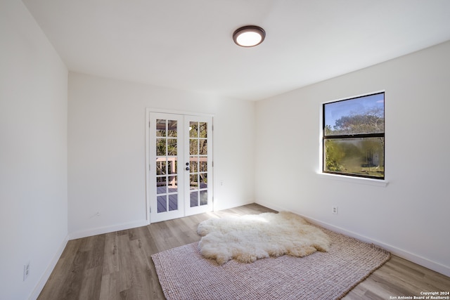 unfurnished room with light hardwood / wood-style floors and french doors