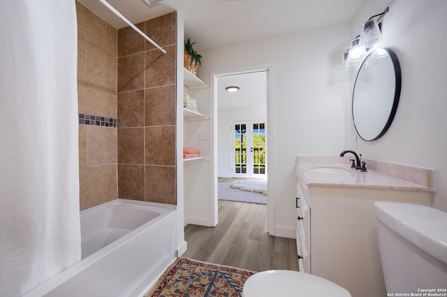 full bathroom featuring hardwood / wood-style floors, vanity, shower / bath combo, and toilet