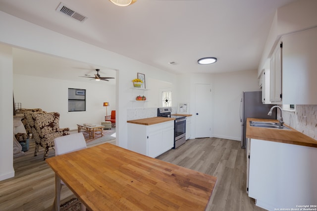 kitchen with appliances with stainless steel finishes, light wood-type flooring, ceiling fan, sink, and white cabinetry