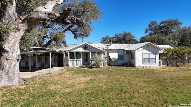 view of front of house with a carport, covered porch, and a front lawn