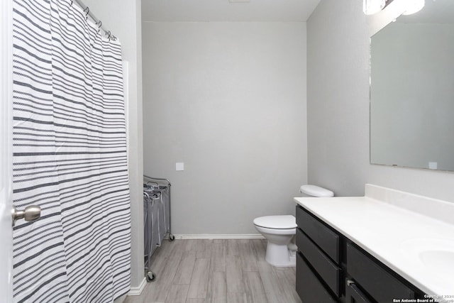 bathroom with hardwood / wood-style floors, vanity, and toilet