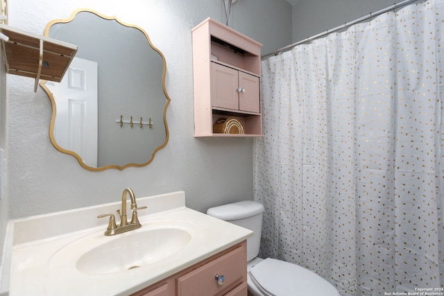 bathroom with curtained shower, vanity, and toilet