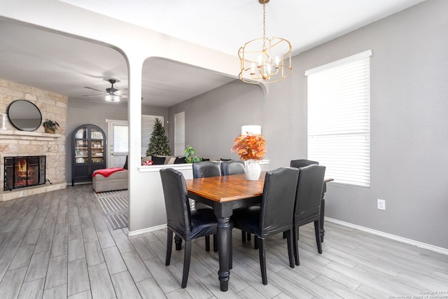 dining space featuring a wealth of natural light, light hardwood / wood-style flooring, and ceiling fan with notable chandelier