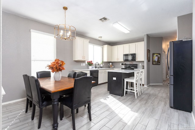 dining space featuring light wood-type flooring and an inviting chandelier