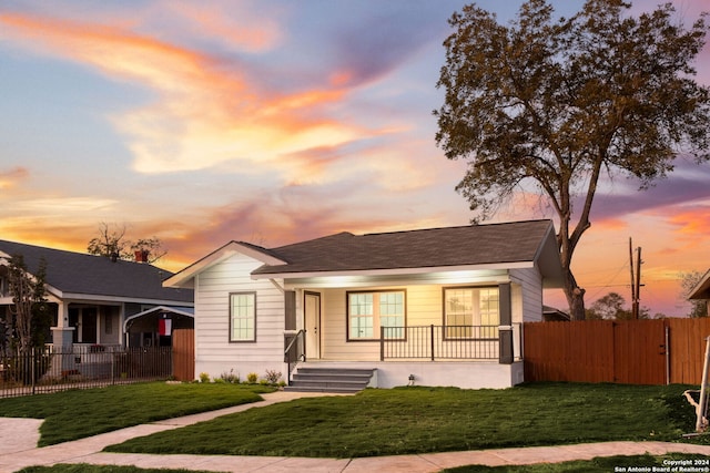 view of front of property with a porch and a yard