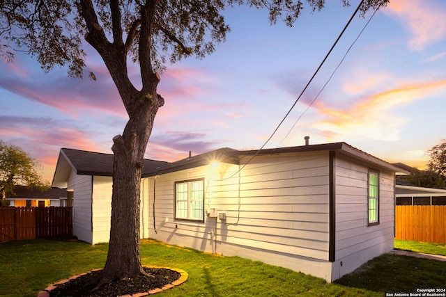 property exterior at dusk with a yard