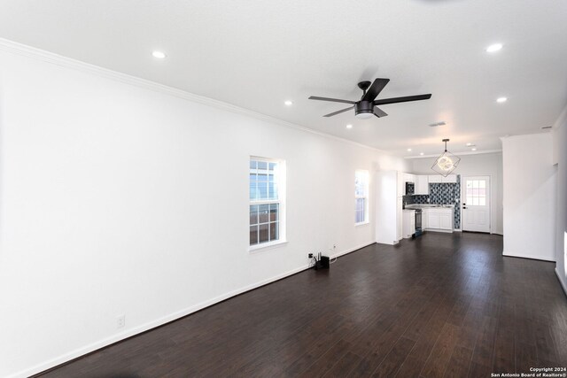 unfurnished living room featuring ceiling fan, dark hardwood / wood-style flooring, and ornamental molding