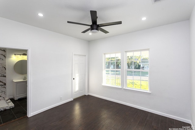 unfurnished bedroom featuring a closet, dark hardwood / wood-style flooring, ensuite bathroom, and ceiling fan