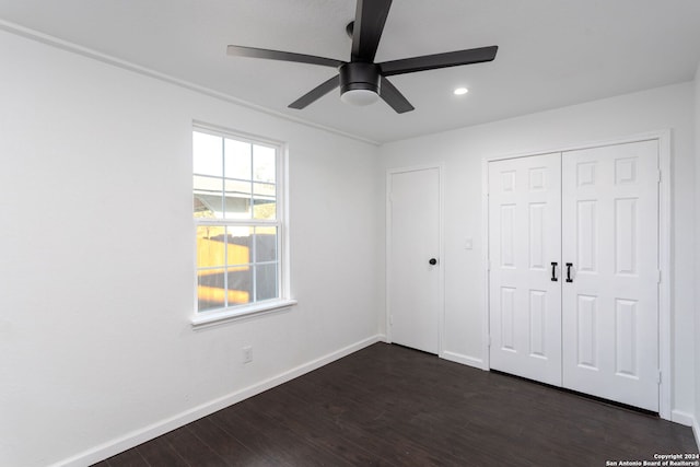 unfurnished bedroom with a closet, dark hardwood / wood-style floors, and ceiling fan