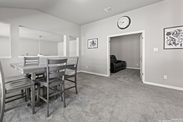 carpeted dining room with lofted ceiling