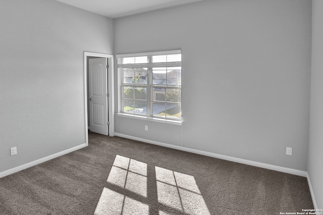 unfurnished room with dark carpet