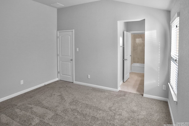 unfurnished bedroom with light carpet and ensuite bath