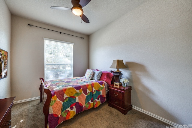 carpeted bedroom with ceiling fan and a textured ceiling