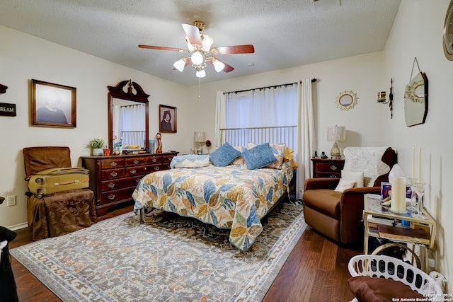 bedroom featuring ceiling fan, dark hardwood / wood-style flooring, and a textured ceiling