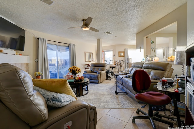 tiled living room featuring ceiling fan and a textured ceiling