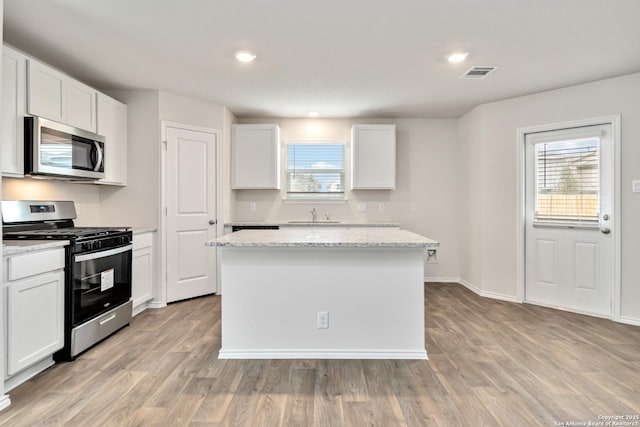1205 Pacific Monarch, San Antonio, TX 78253 - kitchen featuring appliances with stainless steel finishes, a sink, light wood-style floors, white cabinetry, and recessed lighting