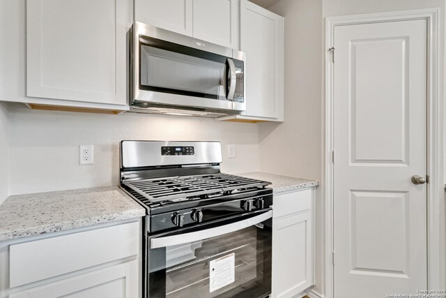 1205 Pacific Monarch, San Antonio, TX 78253 - kitchen featuring appliances with stainless steel finishes, white cabinetry, and light stone counters