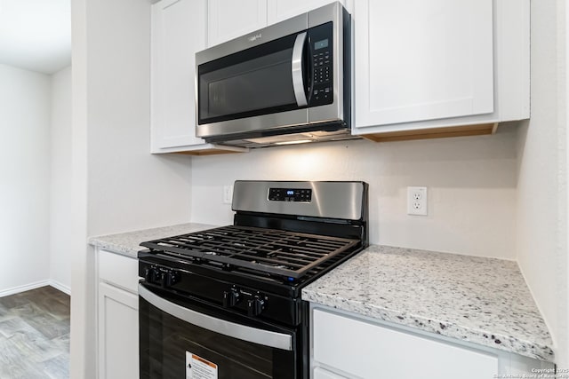 1205 Pacific Monarch, San Antonio, TX 78253 - kitchen featuring gas range, stainless steel microwave, white cabinetry, and wood finished floors