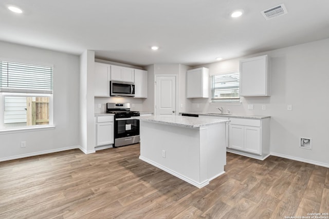 1205 Pacific Monarch, San Antonio, TX 78253 - kitchen featuring stainless steel appliances, a sink, light wood-style floors, white cabinetry, and recessed lighting