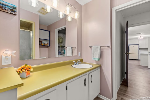 bathroom with vanity, wood-type flooring, and a shower with door